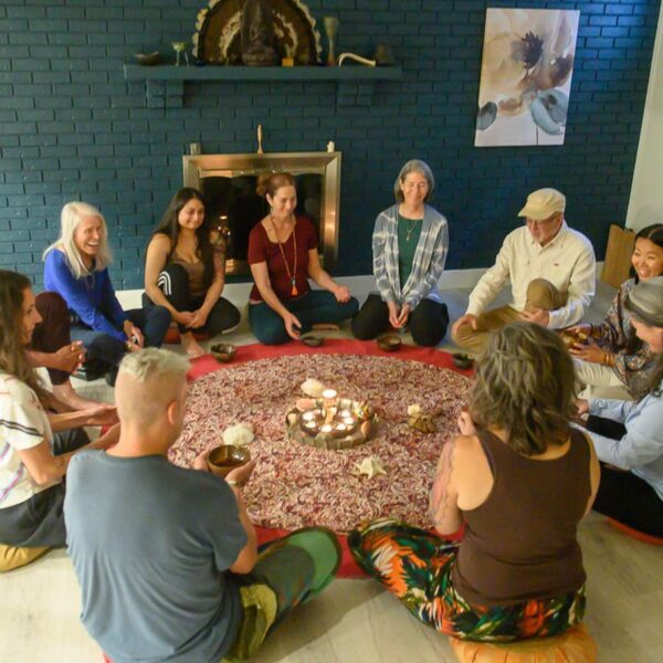 A small circle of people seated around candlelight for a ceremony at Soul Medicine Sanctuary in Longmont, Colorado.